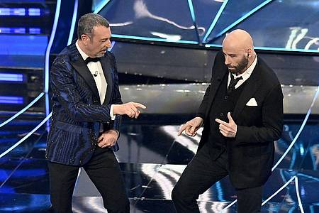John Travolta (r) und Amadeus treten während des Sanremo-Musikfestivals auf.