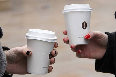 zwei Hände mit Kaffee to-go Bechern