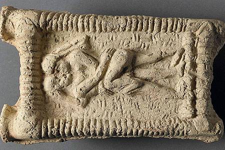 Babylonisches Tonmodell: Ein nacktes Paar auf einer Couch beim Sex und Küssen.