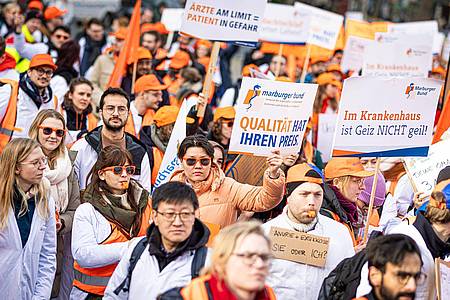 Menschen nehmen an einer Demonstration von Uniklinik-Ärzten auf dem Opernplatz in Hannover teil.