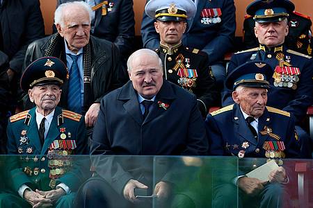 Der belarussische Präsident Alexander Lukaschenko (M.) beobachtet neben Veteranen die Militärparade zum Tag des Sieges anlässlich des 78. Jahrestages des Endes des Zweiten Weltkrieges auf dem Roten Platz in Moskau.