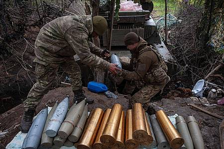 Ukrainische Soldaten bereiten Haubitzengranaten vor.