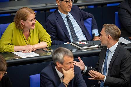 Finanzminister Christian Lindner (FDP) spricht im Bundestag mit Familienministerin Lisa Paus (Grüne).