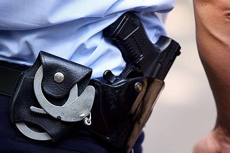 Ein Polizist trägt Handschellen bei sich: Die Bundespolizei hat mutmaßliche Schleuser festgenommen.