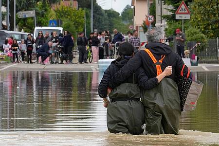Ein Paar auf einer überfluteten Straße im norditalienischen Lugo.