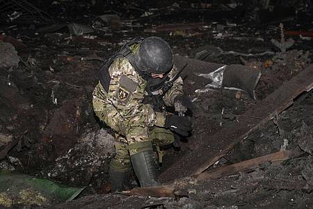 Ein ukrainischer Soldat inspiziert Trümmer eines eingestürzten Gebäudes. (Symbolbild).