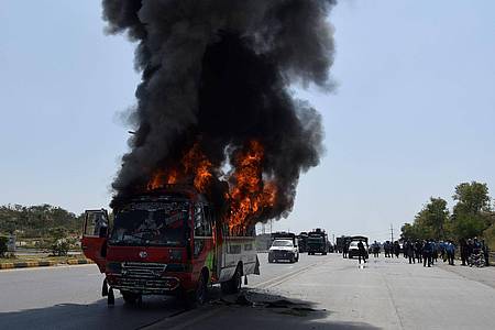Rauch steigt aus einem brennenden Bus während Zusammenstößen von Anhängern des ehemaligen pakistanischen Premierministers Khan und der Polizei.