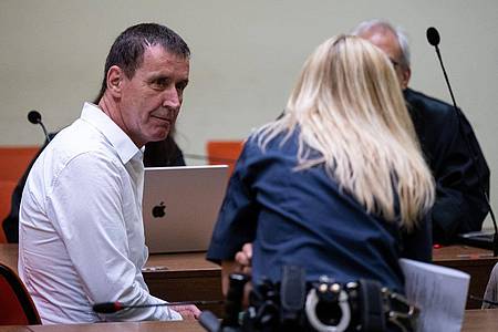 Manfred Genditzki (l) sitzt vor Prozessbeginn im Wiederaufnahmeverfahren um den sogenannten Badewannen-Mordfall im Gerichtssaal.